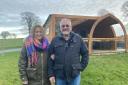 Hilary and Mark outside one of their lodges at Hedgerow Luxury Glamping