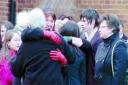 LAST RESPECTS: Mourners comfort each other