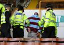 ARREST: A Burnley fan is hauled away after trouble flared at the end of yesterday’s derby