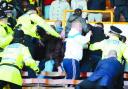 CASE CLOSED: Police tackle Burnley supporters in the David Fishwick Stand at Turf Moor after trouble flared at the end of the game on March 28