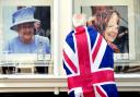 A person looks at pictures of Queen Elizabeth II in a gallery window near Windsor Castle, Berkshire, following the death of Queen Elizabeth II. John Walton/PA