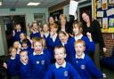 TOP ACHIEVERS: Delighted headteacher Mrs Pam Macro, paper in hand, and deputy head Mrs Nicola White, right, celebrate the results with pupils at St Veronica’s Primary School, Helmshore