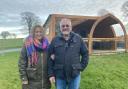 Hilary and Mark outside one of their lodges at Hedgerow Luxury Glamping