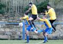SYNCHRONISED: Barnoldswick Town players, in blue and yellow, challenge for the ball