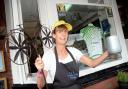 PEDAL POWER: Deborah Gowans, of CJ’s Coffee Shop, Whalley, shows off the cycle-themed window and flower pot