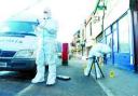 EVIDENCE: Forensic officers search the scene after the raid