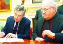 Write away: Gordon Brown puts pen to paper, watched by Coun Colin Rigby