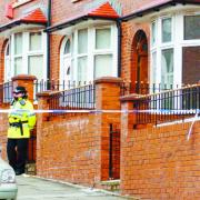 OFF LIMITS: Police guard the house, on the right, in Grindleton Road, Blackburn, where the man’s body was found