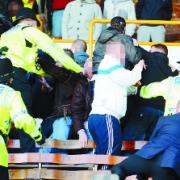 CASE CLOSED: Police tackle Burnley supporters in the David Fishwick Stand at Turf Moor after trouble flared at the end of the game on March 28