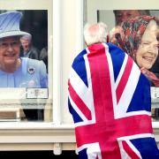 A person looks at pictures of Queen Elizabeth II in a gallery window near Windsor Castle, Berkshire, following the death of Queen Elizabeth II. John Walton/PA