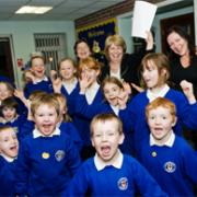 TOP ACHIEVERS: Delighted headteacher Mrs Pam Macro, paper in hand, and deputy head Mrs Nicola White, right, celebrate the results with pupils at St Veronica’s Primary School, Helmshore