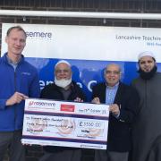 Dan Hill, chief officer of Rosemere Cancer Foundation, far left, receives a cheque for the bladder scanner from Ibrahim Vali Bux, Abdul Aziz Patel and Habibullah Munshi
