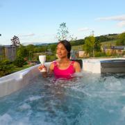 A woman in a hot tub at one of the lodges at the Everything Retreat