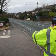 A Community Roadwatch Volunteer checking the speed of motorists