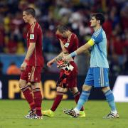 From left, Spain's Fernando Torres, Andres Iniesta and goalkeeper Iker Casillas walk off the pitch following their group B World Cup soccer match between Spain and Chile at the Maracana Stadium in Rio de Janeiro, Brazil