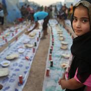 An Iraqi girl waits with others for a communal meal to break their fast at sunset during the first day of the Islamic holy month of Ramadan