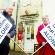 APPALLED: Ward councillor Marlene Haworth and Hyndburn Council deputy leader, Coun Brian Roberts, with their protest placards outside Belthorn Post Office, one of 24 across East Lancashire earmarked for closure