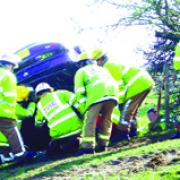SCENE: Fire officers  work to make one of the crash cars safe