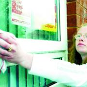 CLEAN UP: Carol wipes away the NF' initials which had been daubed on the windows at her home