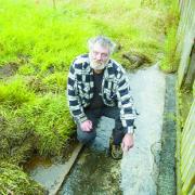 ANGRY: Resident Ian Walker points out green slime which runs down a path at the back of his bungalow home in Holmbrook Close, Higher Croft, Blackburn