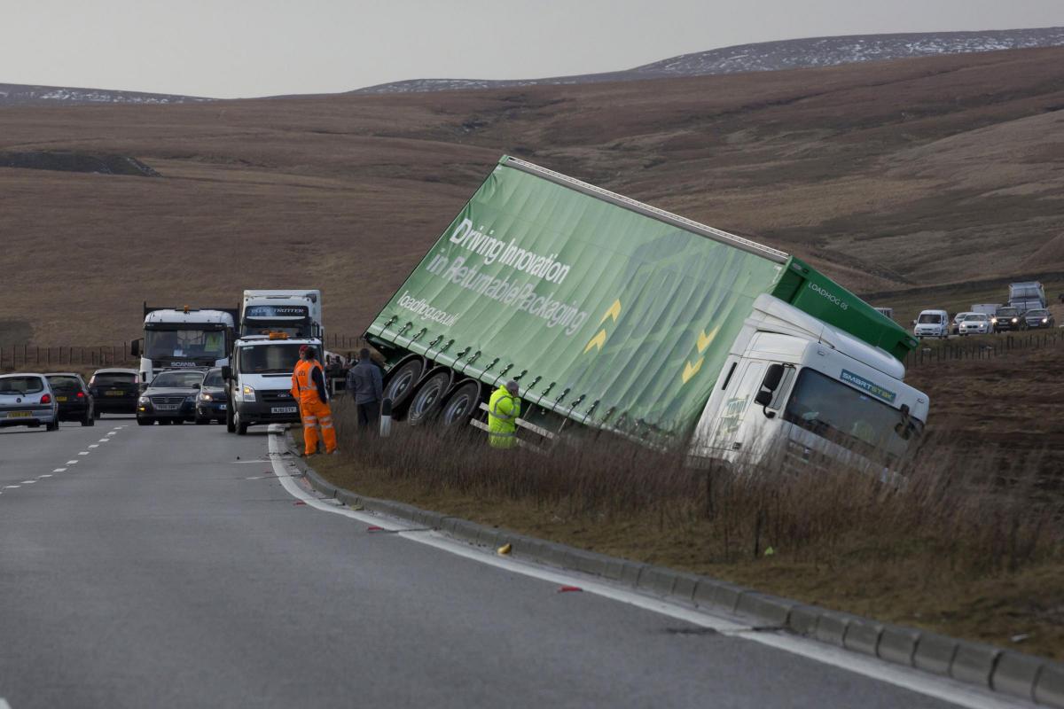 A truck is seen after being blown off the road on the A628, Woodhead Pass, near Preston  between Manchester and Sheffield, England, Wednesday, Feb. 12, 2014. Winds gusting at speeds approaching 100mph are battering parts of the UK after the  Met Office is