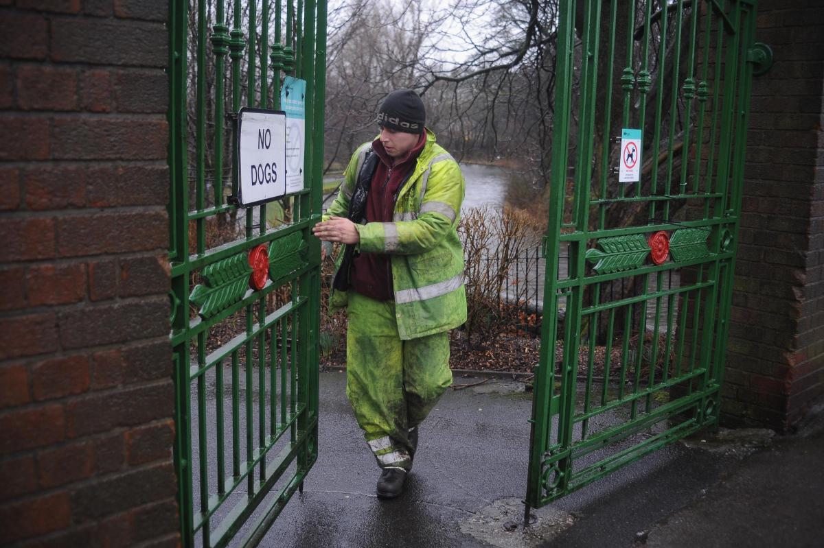 Burnley Council's Brendan Conlan shuts the gates to close Thompson Park because of the closeness of the trees to walkways.