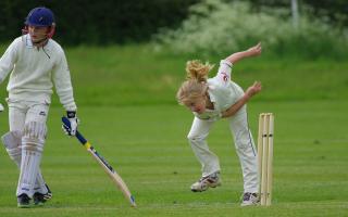 A stock image of children playing cricket