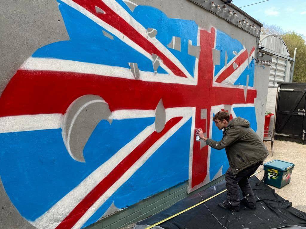 Keiron Curly Whitehead, Darwens resident grafitti artist has painted a huge Union Jack on the side of the British Queens beer garden ready for the pubs re-opening on May 17