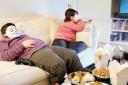 Obese children sitting on a sofa
