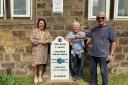 Headteacher, Naomi Healey, artists  Shane Johnstone and Cliviger Parish Council chairman, Ivor Emo with the milestone.