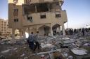 Palestinians look at destruction after an Israeli strike on the Gaza Strip in Khan Younis,