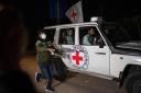 A Red Cross vehicle carrying Israeli hostages drives by at the Gaza Strip crossing into Egypt in Rafah on Saturday (Fatima Shbair, AP)