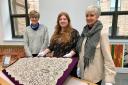 Volunteers Vickie Dewhurst and Gill Lawson and Gawthorpe Textiles Collection curator Rachel Midgeley, centre