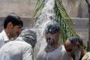People cool themselves off with water in Peshawar, Pakistan. Over 1000 people lost their lives due to a weeklong heat wave in the Karachi