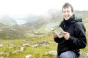 Stuart Maconie peruses his Wainwright guide in the Lakeland Fells