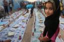 An Iraqi girl waits with others for a communal meal to break their fast at sunset during the first day of the Islamic holy month of Ramadan