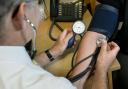 A doctor checking a patient's blood pressure. Credit: PA