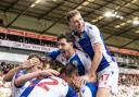 Sam Szmodics is mobbed by his team mates after scoring his side’s second goal