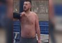 Police have released a CCTV image of a topless man after a train conductor was assaulted