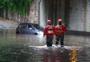 Emergency service rescuing several person from a vehicle after flooding