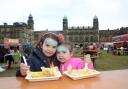 Cousins Sophie Warburton and Emmie Avci enjoy the arrival of the Sun as they eat their chips on the Stonyhurst College lawn at the Great British Food Festival