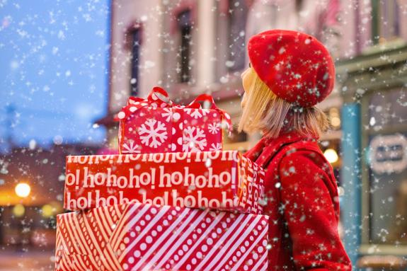 Lancashire Telegraph: A woman dressed in red carrying Christmas presents in the snow. Credit: Canva Lancashire Telegraph: A woman dressed in red carrying Christmas presents in the snow. Credit: Canva