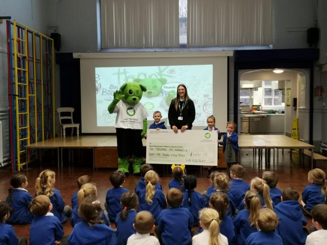 Georgia Sleigh, fundraising offticer for Manchester Children's Hospital collecting the cheque from the Ashleigh Primary School pupils