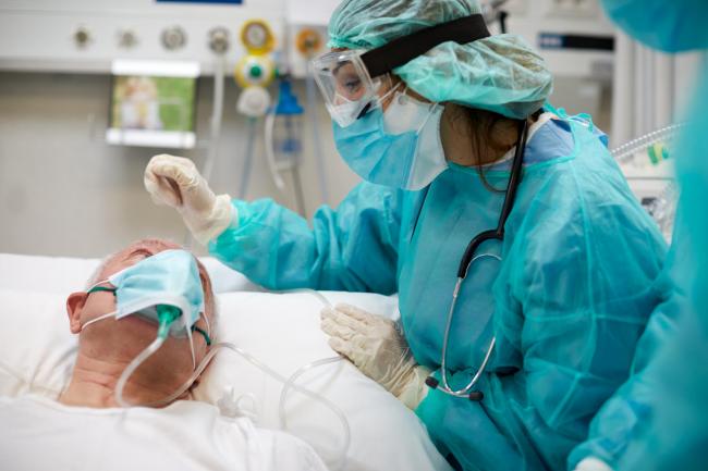 ADMISSIONS: A nurse is comforting a Covid patient at an intensive care unit
