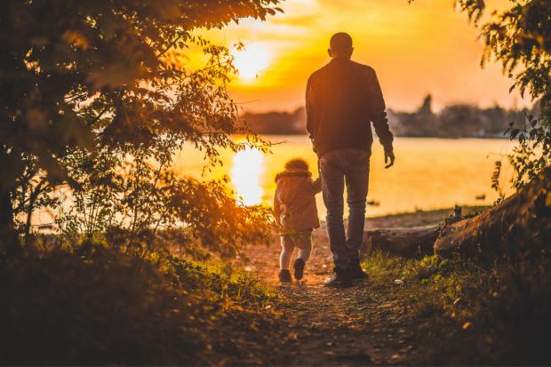 Lancashire Telegraph: Father and child walking together at sunset. Credit: Canva