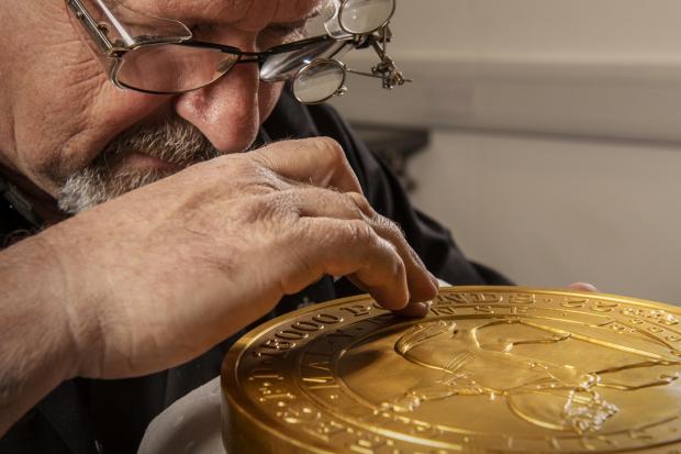 Lancashire Telegraph: Master craftsman Steve Dyer works on the 15 kilo gold coin by hand. Credit: The Royal Mint