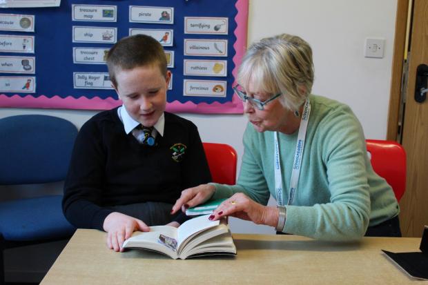 Lancashire Telegraph: Schoolreader volunteer Freda with a primary school pupil