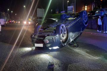 Car overturns after crash on busy Blackburn road