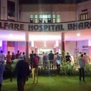 People stand around the Welfare Hospital after the deadly fire in Bharuch, western India, Saturday, May 1, 2021.