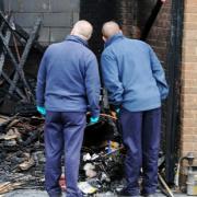 FIRE PROBE Fire investigation officers examine the aftermath